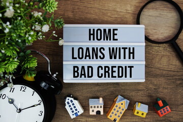 Home Loans With Bad Credit text in lightbox with house model, magnifying glass and alarm clock on...