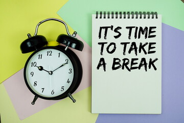 It's time to take a break text written on notepad with alarm clock on pastel background
