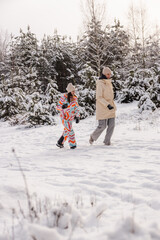 Young woman and teenage girl walking through snowy pine forest, winter outdoor lifestyle scene with natural light, fresh snowfall, peaceful mood