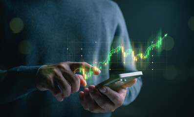 Trader or investor using smartphone with glowing stock market chart and upward trend, symbolizing digital trading, investment growth, fintech analytics, real-time data, and financial decision making.