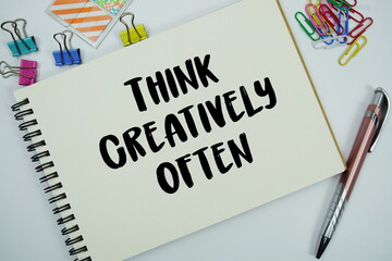 Think Creatively Often text message written on notepad with stationery flat lay on white background