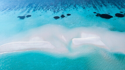Fototapeta premium Aerial view with crystal clear with summer lagoon ripples in the sand at low tide on a beach with sandbar and blue sea in Raja ampat,indonesia