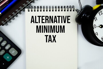 Alternative Minimum Tax text written on notepad with calculator and alarm clock