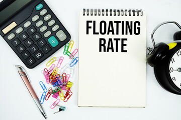 Floating Rate text written on notepad with calculator and alarm clock