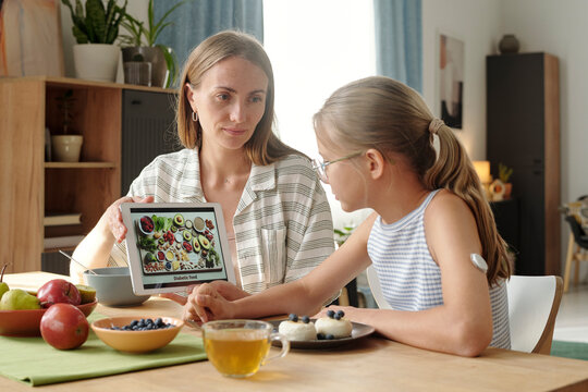 Mother and daughter with insulin patch discussing diabetic meal at home