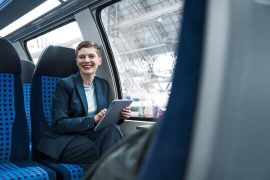 Businesswoman working on a tablet in train compartment