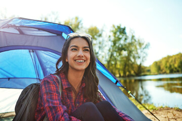 Camping, happy or woman at lake with tent, fresh air or outdoor hobby in forest. Smile, bokeh or backpacker in nature with equipment, calm environment and observation in sightseeing activity.