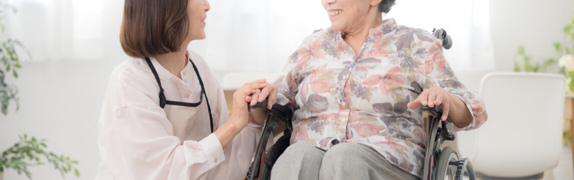 自宅で車椅子の母を介護をする様子　見つめ合う会話をする顔なしのバナー