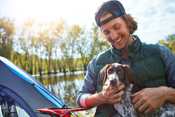 Happy man, pet and dog outdoor with tent for camping trip, adventure or companion for bonding together. Person, smile and puppy in nature with campsite, connection and loyalty for getaway on weekend.