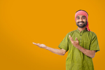 Happy Young Indian farmer standing on Yellow background.