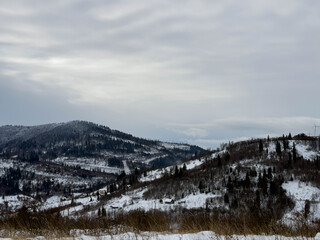 Mystical snowy Carpathian peaks under cloudy skies