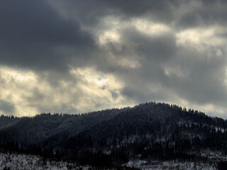 Mystical snowy Carpathian peaks under cloudy skies