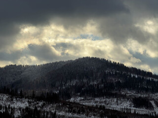 Mystical snowy Carpathian peaks under cloudy skies