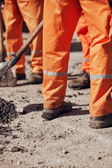 Construction workers working on a new asphalt layer on a public street.