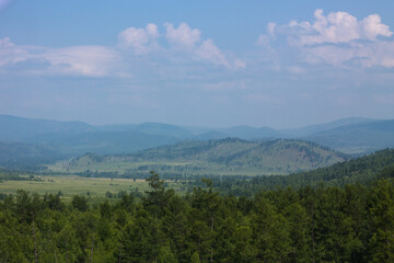 Fototapeta premium Landscape with mountains, forests and clouds. View from the top of the mountain.