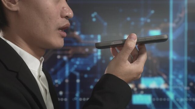 Asian businessman speaking into smartphone for voice command against futuristic digital circuit background, symbolizing artificial intelligence, smart technology, digital assistant usage