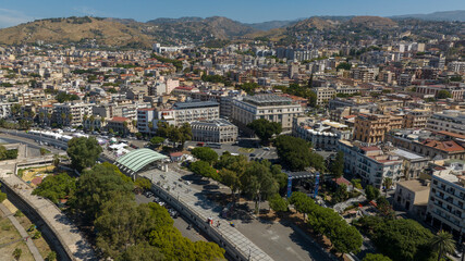 Naklejka premium Aerial view of the historic center of Reggio Calabria, Italy. In the foreground is the tree-lined promenade of the city. It is a sunny summer morning.