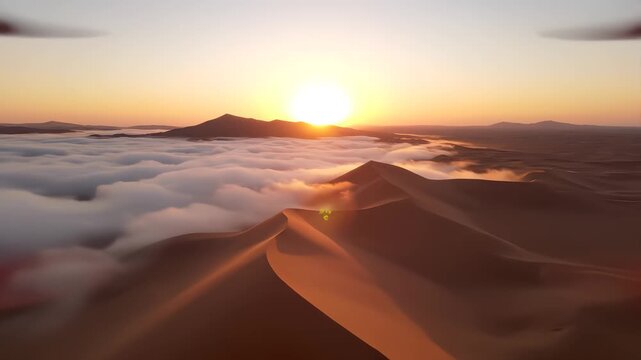 Aerial view of a drone flying over massive sand dunes covered by thick fog clouds at sunrise. desert.