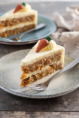 Carrot cake slice with cream cheese frosting on wooden table