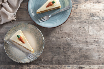 Carrot cake slice with cream cheese frosting on wooden table. Top view. Copy space