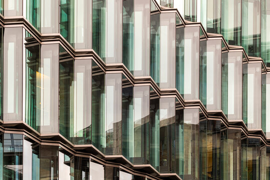 Green glass facade pattern with geometric texture on modern corporate architecture building creating abstract urban background for business design