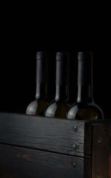 Wine bottles without labels in a wooden box on a dark background