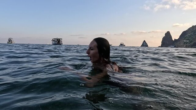 Swimming, Diving, Woman, young woman in red swimsuit dives underwater in clear sea during summer vacation.