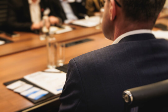 Diplomatic delegation meeting negotiation, group of men in business suits talking and discussing at conference, politicians debate and negotiate, businessmen have dialog, conversation on forum summit