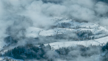 Aerial view of rural villages in Bosnia and Herzegovina during winter, with snow covered fields,...