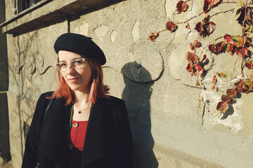 Portrait of a young woman in the street by the house wall