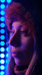 Beautiful blonde woman eyes close-up by the neon lights
