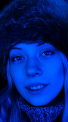 Beautiful blonde woman with a caper in the nightclub portrait closeup with a blue neon light