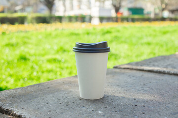 Discarded paper cup on curb as urban pollution concept
