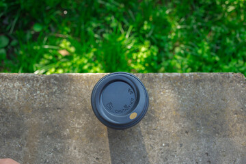 Discarded paper cup on curb as urban pollution concept