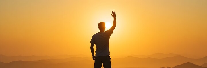 Fototapeta premium Man Standing on Mountain Top with Arm Raised at Sunset Viewpoint