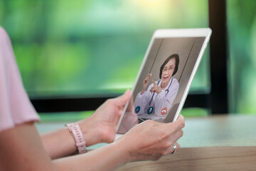 Senior woman holding tablet consults happy doctor in remote healthcare for seniors concept with telehealth visit