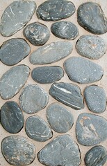 Close-up of Gray Rounded Pebbles on Sandy Ground