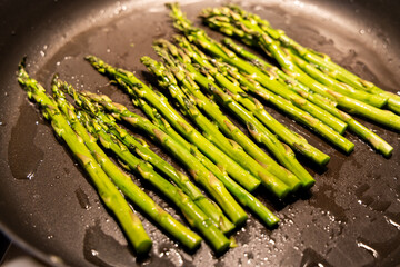 Bunch of asparagus saut&eacute;ed on the pan.