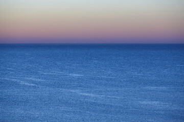 Sunrise by the sea. Horizon line at dusk. Morning sky