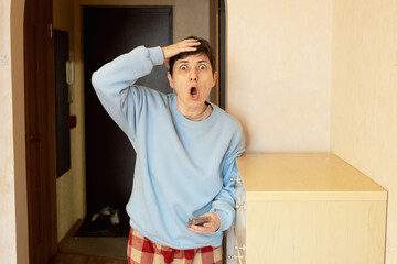 Woman in casual sweater reacting with wide eyes and open mouth to shocking information on her...