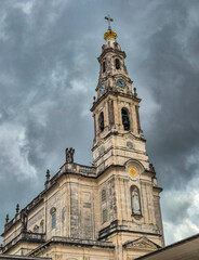 Obraz premium Low angle view of the Clerigos Tower against a dramatic cloudy sky. The baroque structure is one of the city most iconic landmarks.