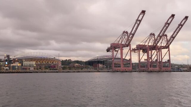 Gimbal wide panning shot of the Port of Seattle with Lumen Field and T-Mobile Park as seen from a moving boat on Elliott Bay in Seattle, Washington. 4K at 30 FPS