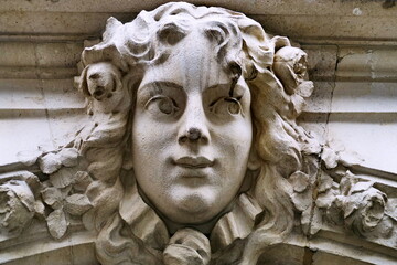 Visage de femme sculpt&eacute; en pierre blanche sur fa&ccedil;ade (Mascaron). Paris. Avenue de Laumi&egrave;re.