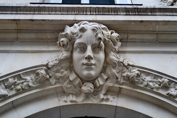 Visage de femme sculpt&eacute; en pierre blanche sur fa&ccedil;ade (Mascaron). Paris. Avenue de Laumi&egrave;re.