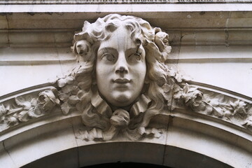 Visage de femme sculpt&eacute; en pierre blanche sur fa&ccedil;ade (Mascaron). Paris. Avenue de Laumi&egrave;re.