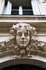 Visage de femme sculpt&eacute; en pierre blanche sur fa&ccedil;ade (Mascaron). Paris. Avenue de Laumi&egrave;re.