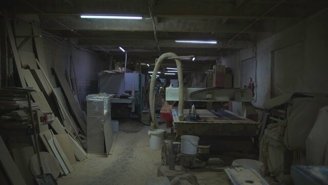 Workshop Cluttered With Equipment And Dust, Crowded Timber Shop Filled With Machinery And Shadows. Media - Powered by Adobe