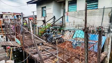 Kota Kinabalu, Malaysia. Illegal Filipino immigrants Bajau live in pile-buildings settlement, slum. Some houses been demolished, residents evicted. Modern high-rise buildings stand in background