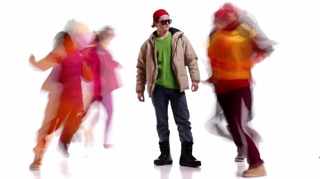 Still male figure in flow of winter street fashion and motion. Concept of urban rhythm, visual contras, modern casual wear, seasonal layers, and contemporary street style aesthetics.