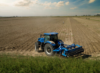 Tractor ploughing a large field. Aurtumn season. 